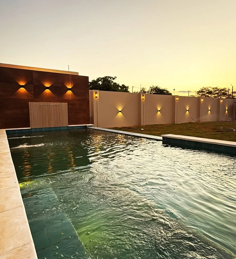 Piscina de la Casa GCh al atardecer, con el muro iluminado
